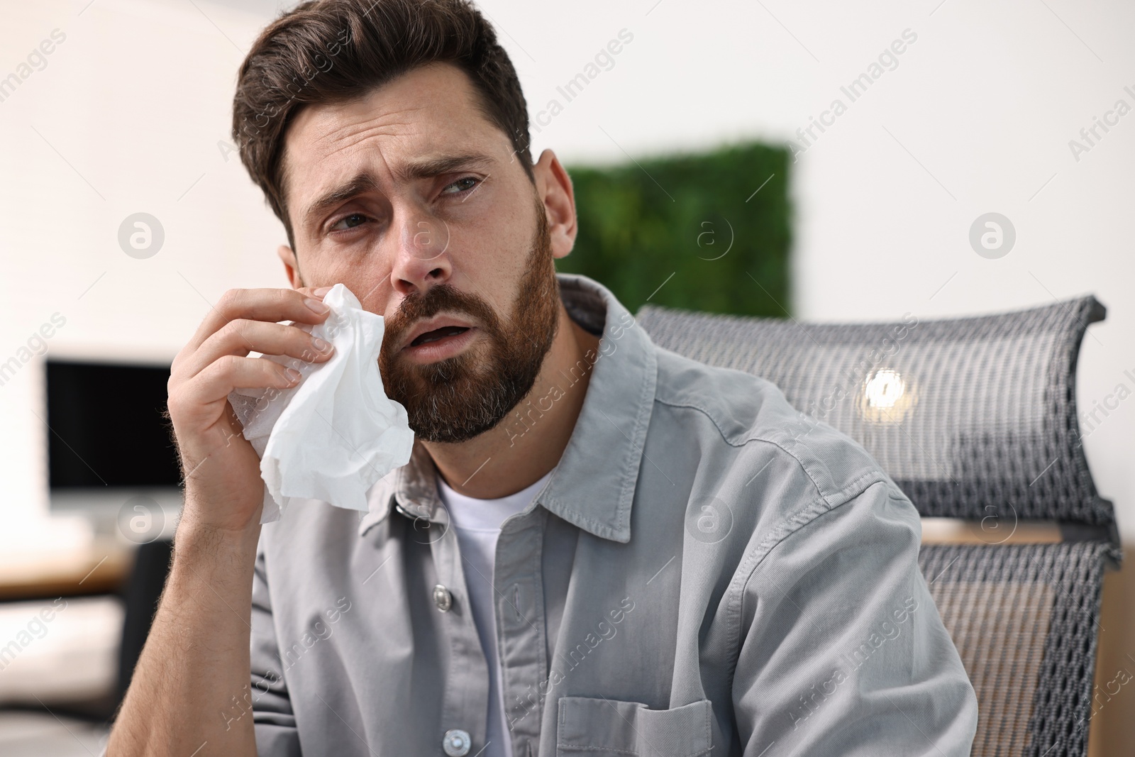 Photo of Sick man with runny nose in office