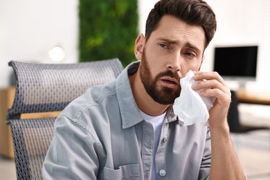 Photo of Sick man with runny nose in office