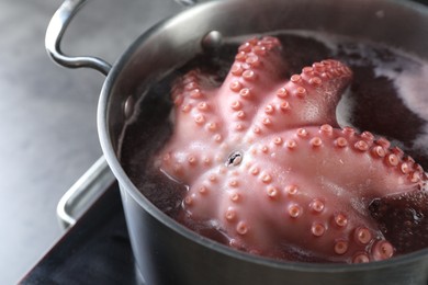 Photo of Fresh octopus boiling in pan on stove, closeup