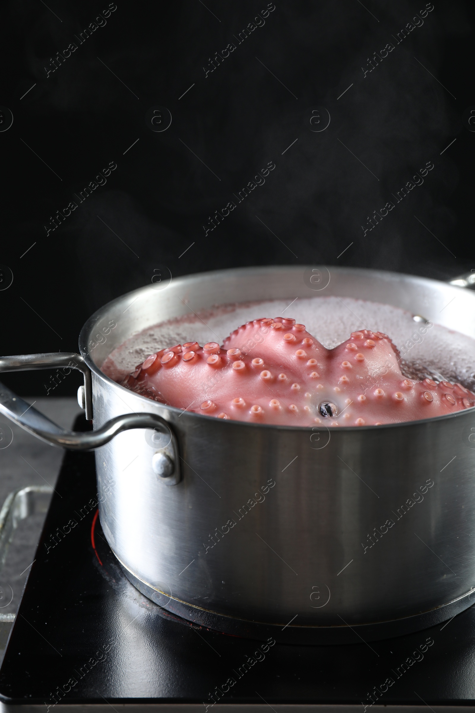 Photo of Fresh octopus boiling in pan on stove, closeup