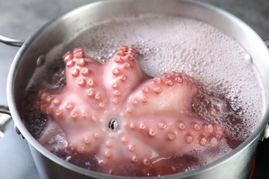 Photo of Fresh octopus boiling in pan on stove, closeup