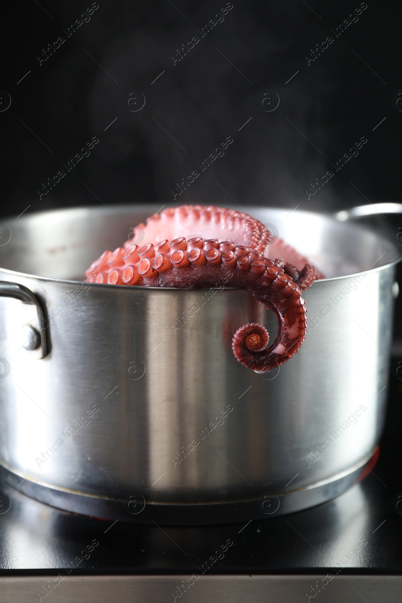 Photo of Fresh octopus boiling in pan on stove, closeup