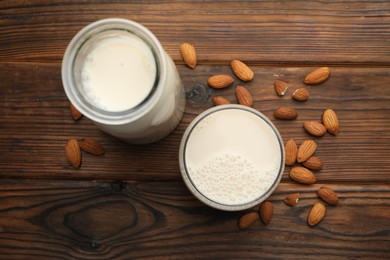 Photo of Fresh almond milk and nuts on wooden table, top view