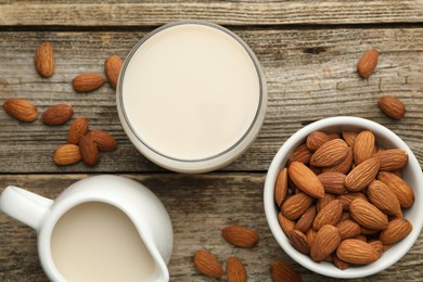 Fresh almond milk and nuts on wooden table, top view