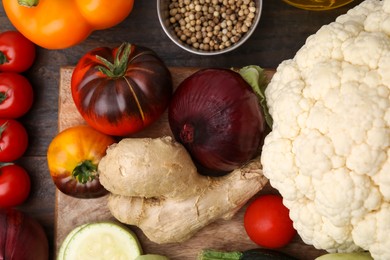 Photo of Cooking tasty stew. Fresh vegetables and peppercorns on wooden table, top view