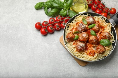 Photo of Delicious pasta with meatballs and ingredients on light grey table, flat lay. Space for text