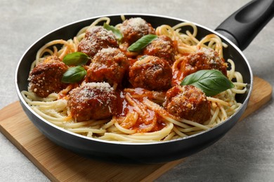 Delicious pasta with meatballs on light grey table, closeup