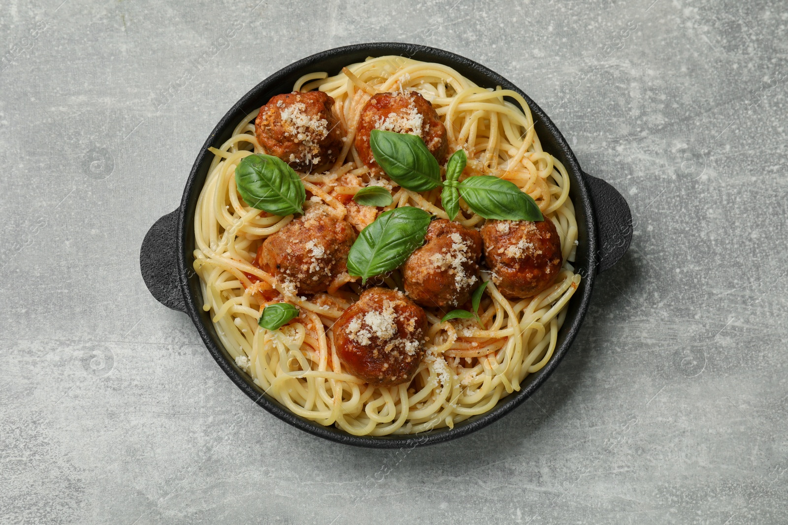 Photo of Delicious pasta with meatballs on light grey table, top view