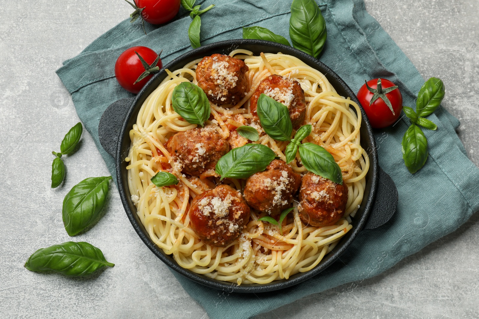 Photo of Delicious pasta with meatballs and ingredients on light grey table, flat lay