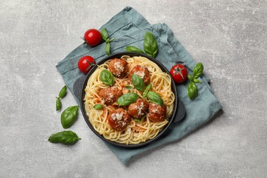 Delicious pasta with meatballs and ingredients on light grey table, flat lay