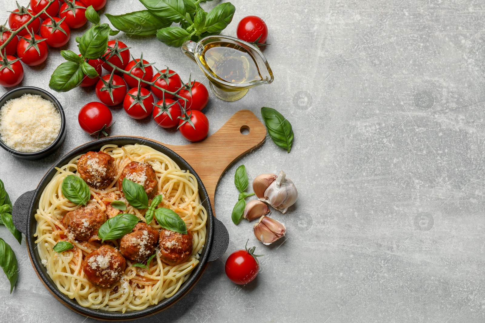 Photo of Delicious pasta with meatballs and ingredients on light grey table, flat lay. Space for text