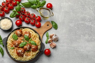 Delicious pasta with meatballs and ingredients on light grey table, flat lay. Space for text