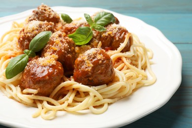 Delicious pasta with meatballs on light blue wooden table, closeup