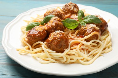 Delicious pasta with meatballs on light blue wooden table, closeup