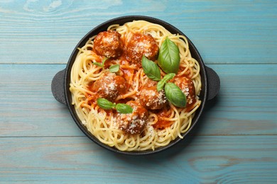 Photo of Delicious pasta with meatballs on light blue wooden table, top view