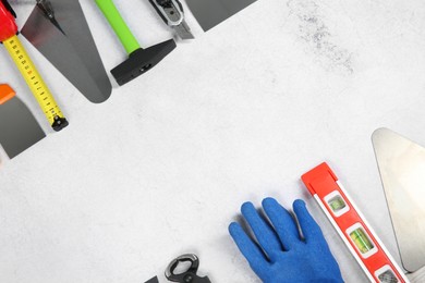 Photo of Many different construction tools on light textured table, flat lay. Space for text