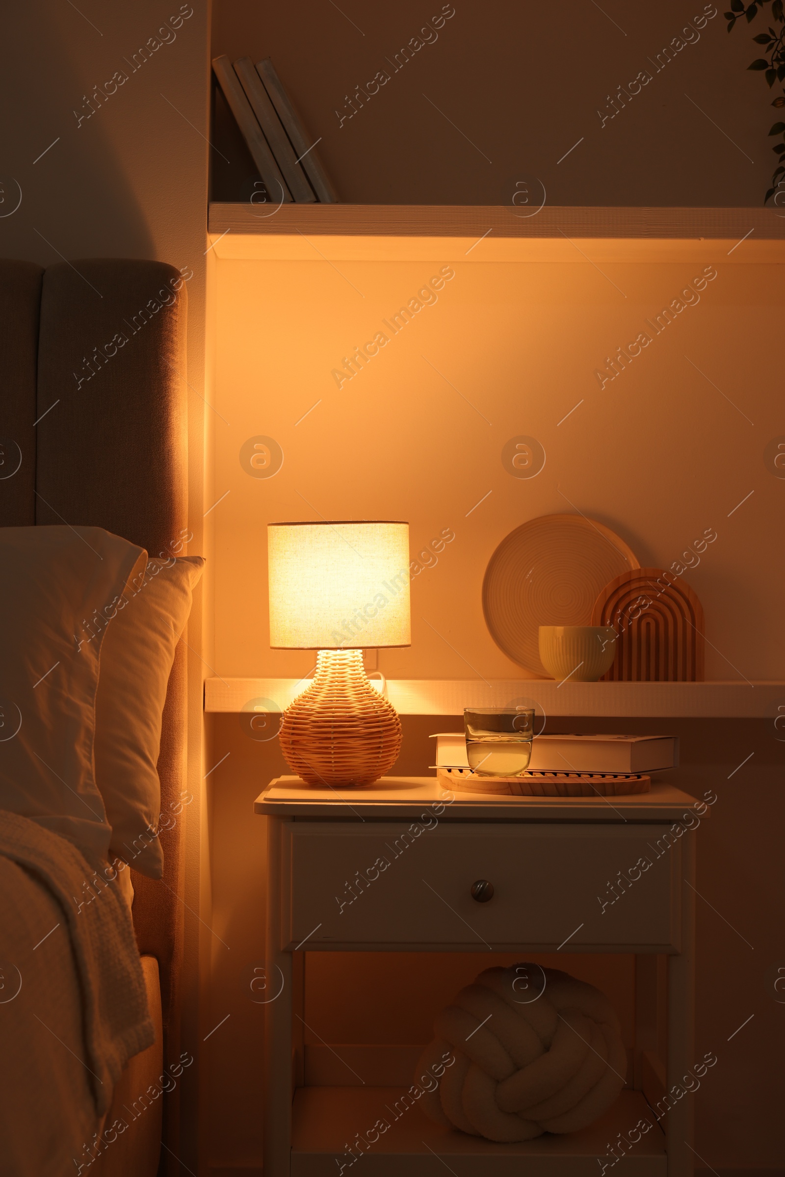 Photo of Stylish living room interior with bed, bedside table and lamp