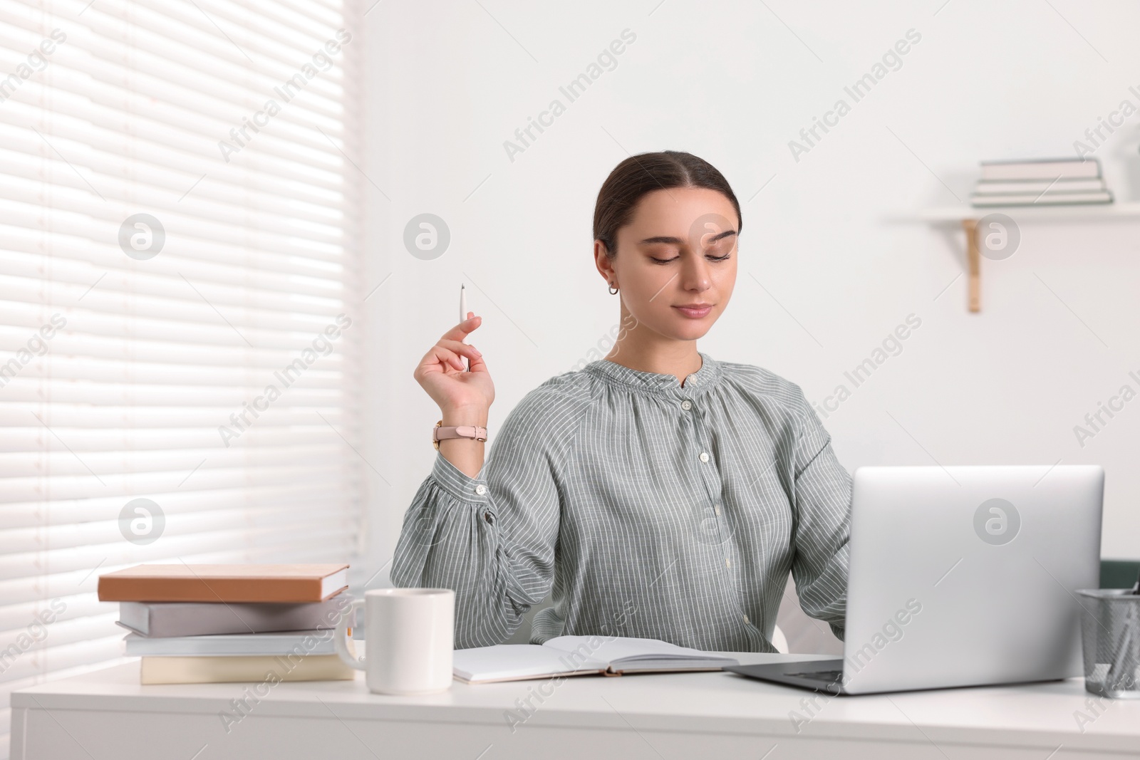 Photo of Student studying with laptop at table indoors