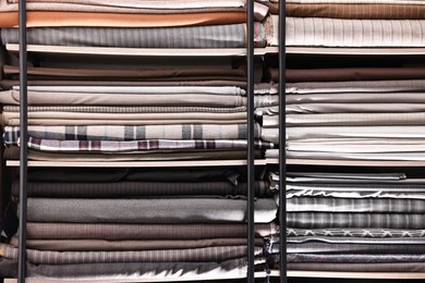 Photo of Many different types of fabric on shelves in professional atelier