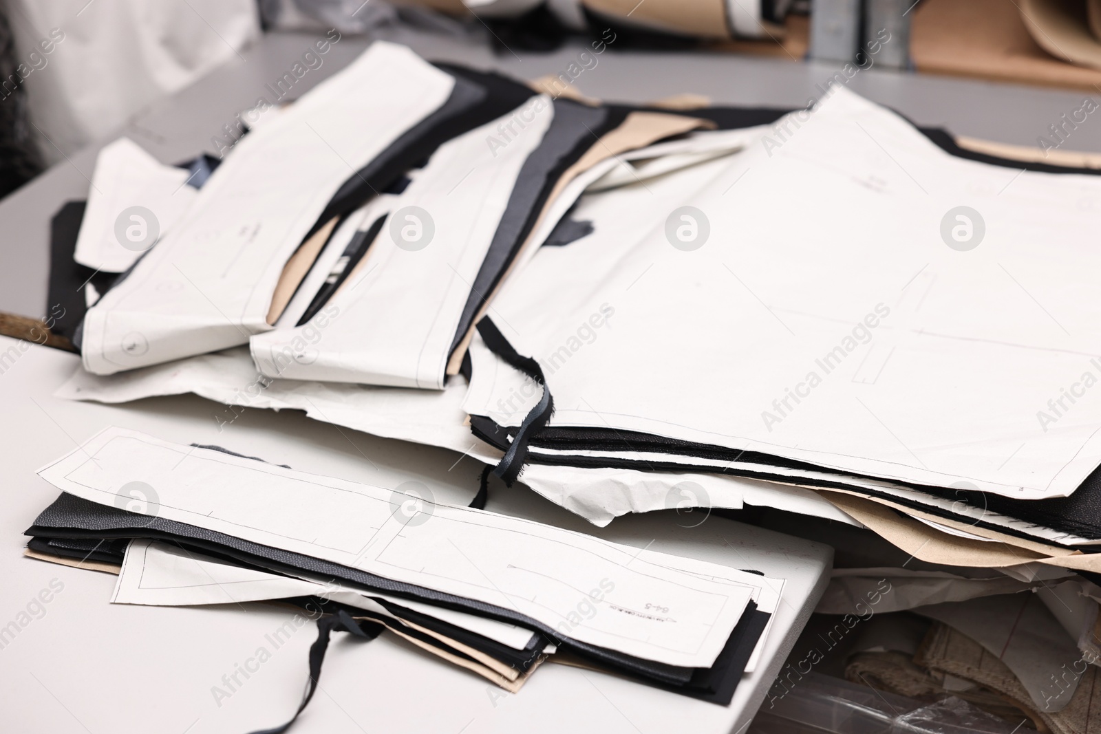 Photo of Pieces of fabric and measurements on white table in professional workshop