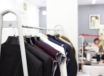 Woman working at professional workshop with different clothes and tools, selective focus