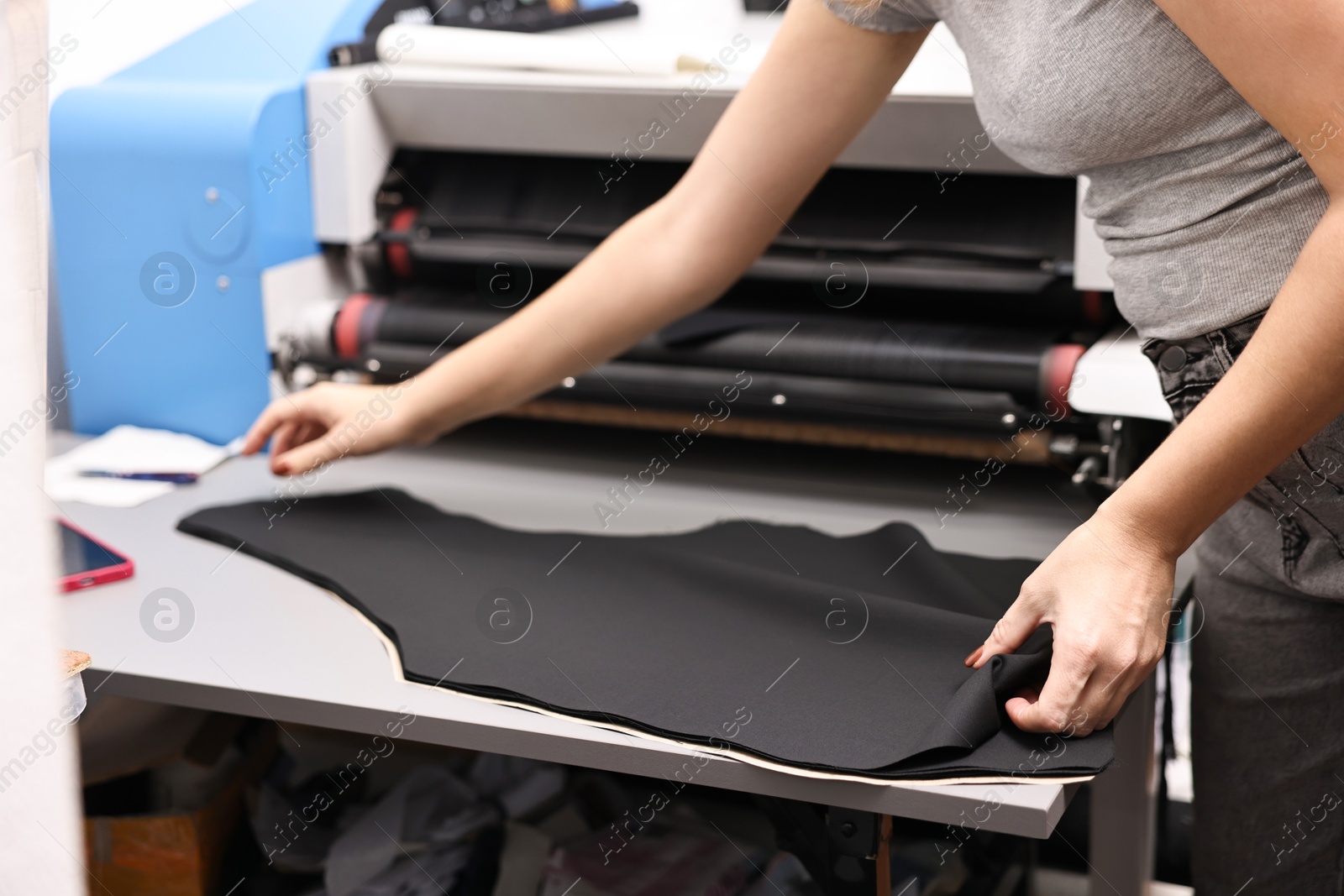 Photo of Young woman working at white table in professional workshop, closeup