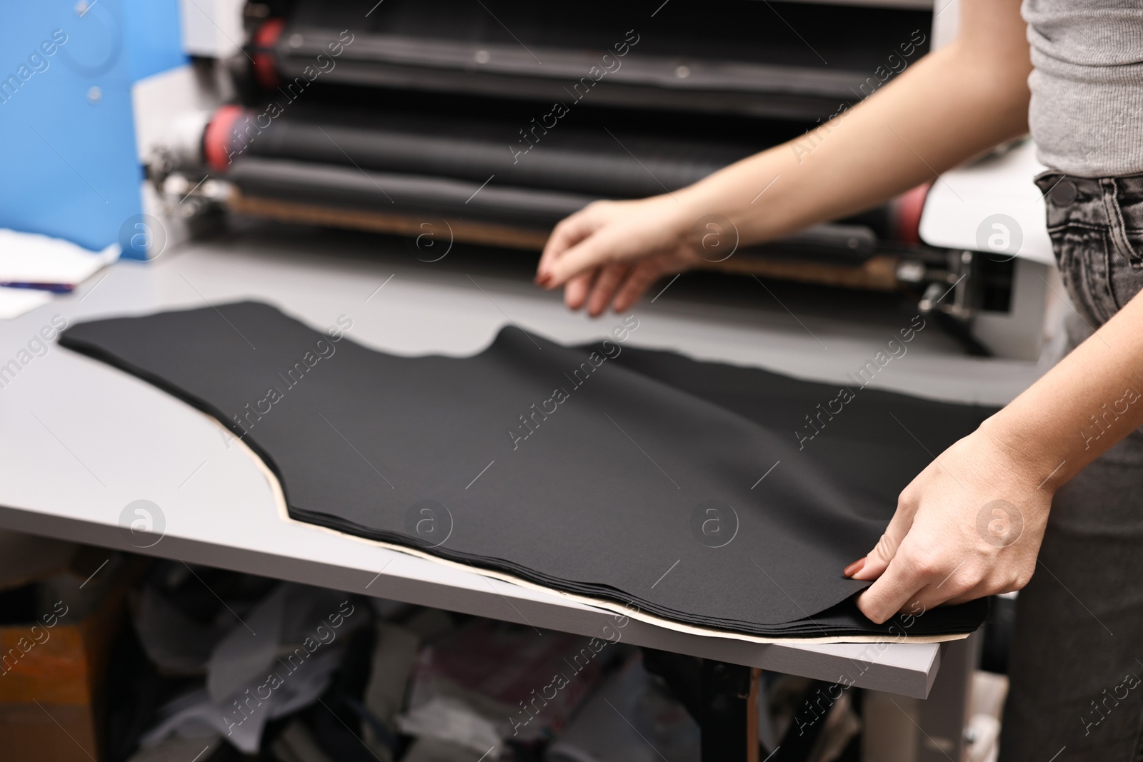 Photo of Young woman working at white table in professional workshop, closeup