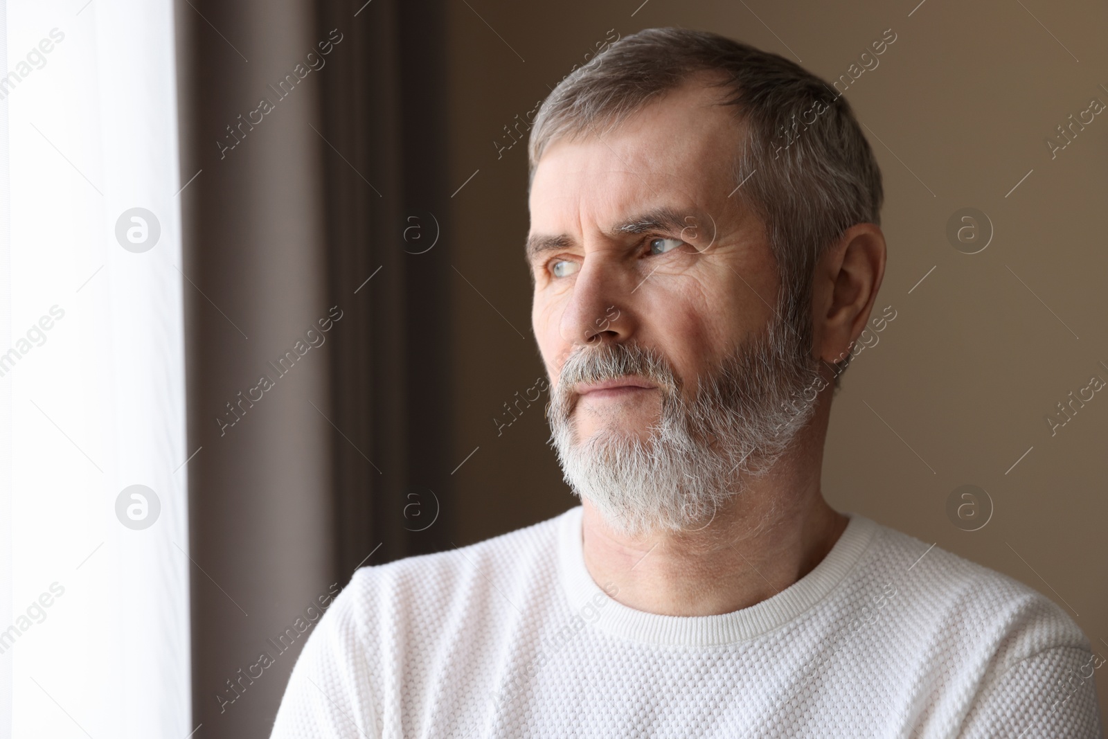 Photo of Portrait of lonely mature man at home