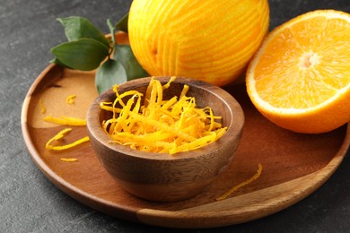 Photo of Fresh orange peel and fruits on black table