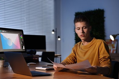 Photo of Designer with color palettes working indoors at night