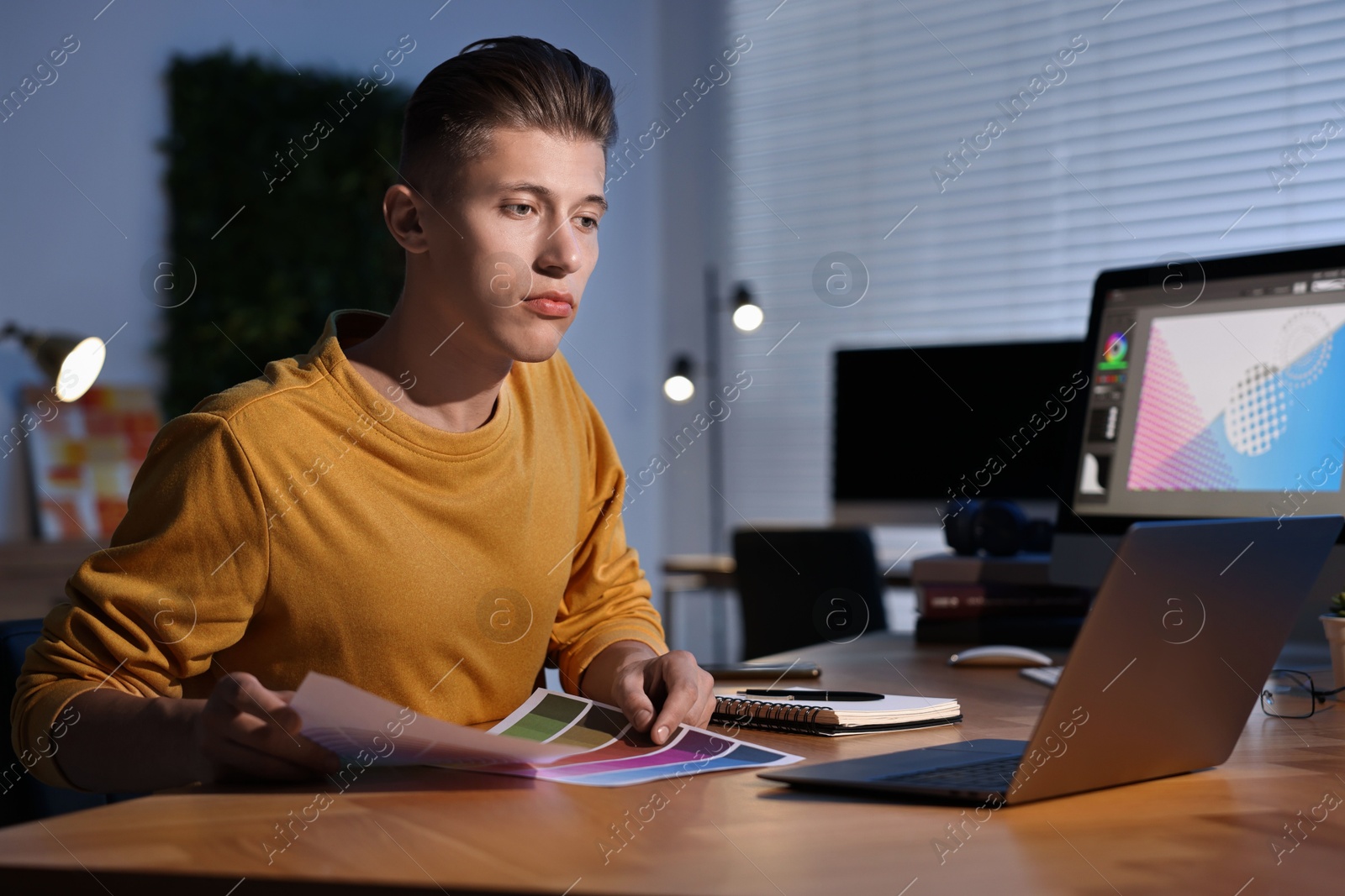 Photo of Designer with color palettes working indoors at night