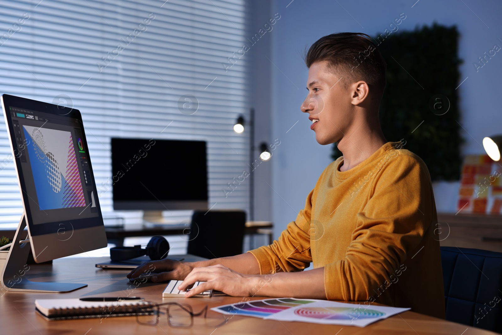 Photo of Designer working on computer indoors at night