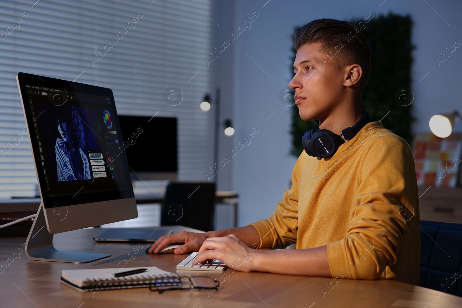 Photo of Designer working on computer indoors at night