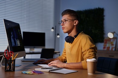 Photo of Designer working on computer indoors at night