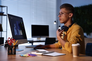 Designer working on computer indoors at night