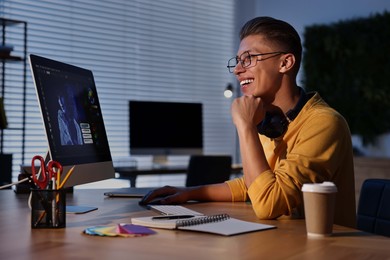 Photo of Designer working on computer indoors at night