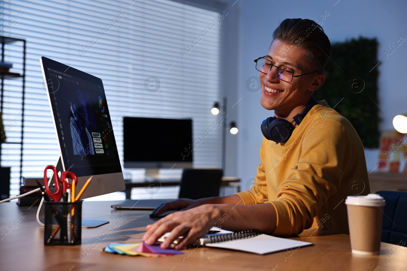 Photo of Designer with color sample cards working indoors at night