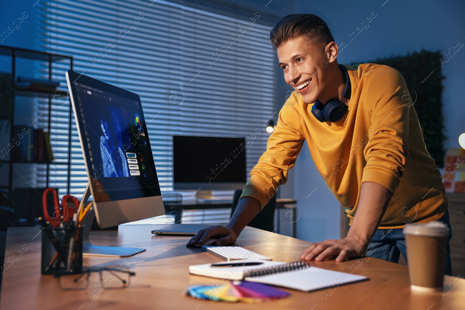 Photo of Designer working on computer indoors at night