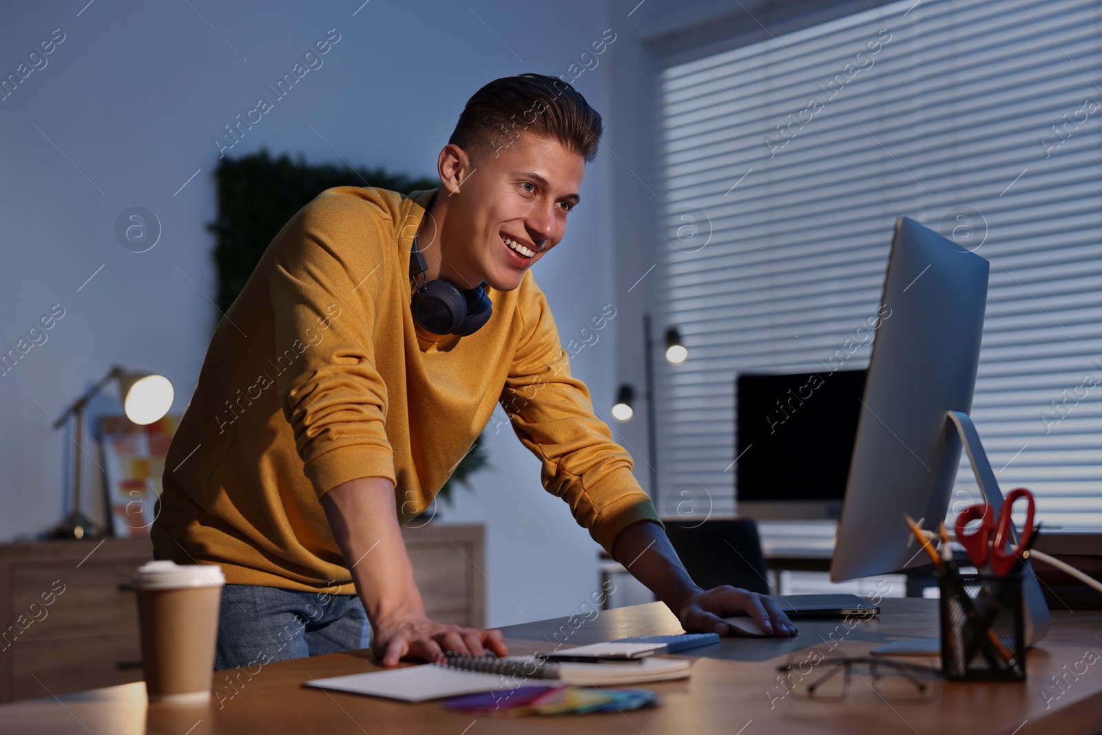 Photo of Designer working on computer indoors at night