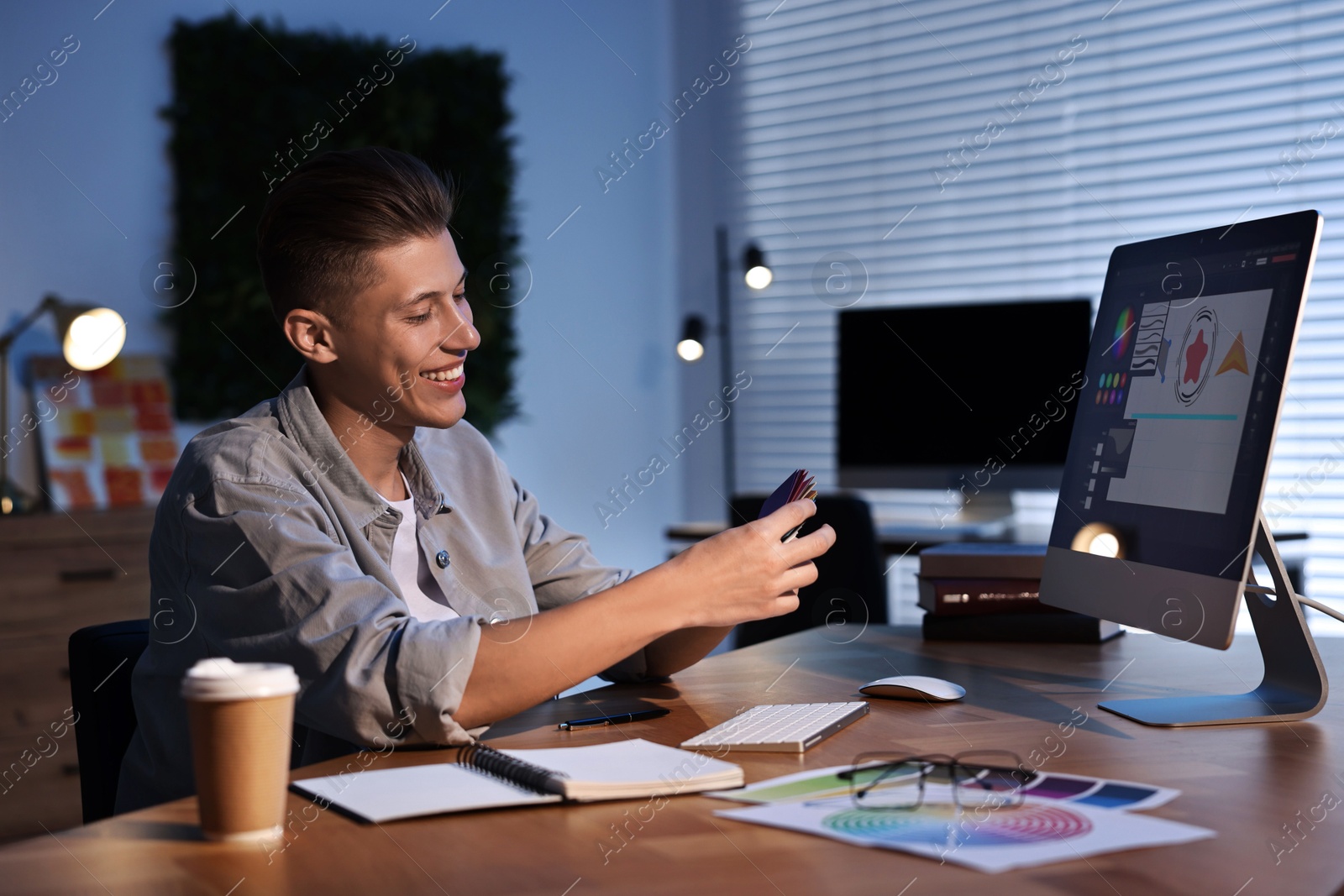 Photo of Designer with color sample cards working indoors at night