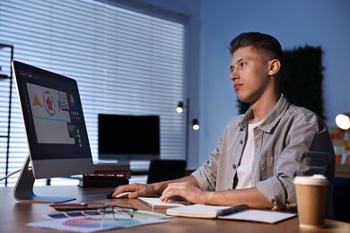 Photo of Designer working on computer indoors at night