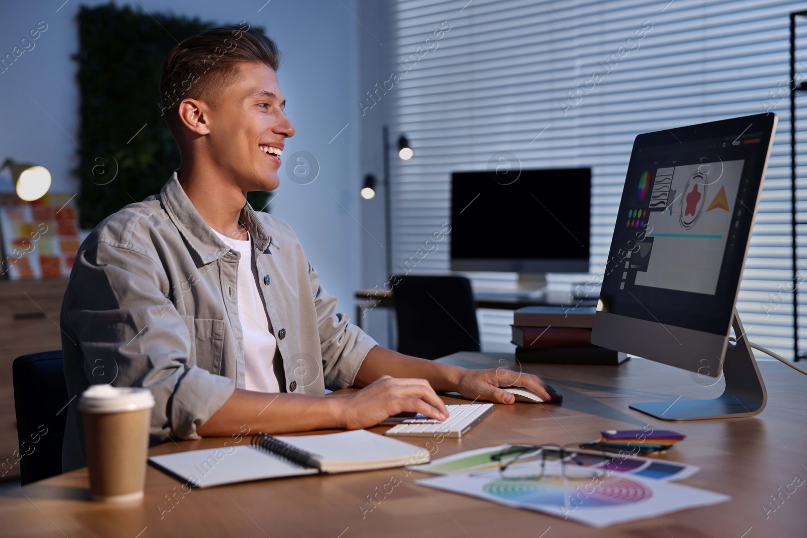 Photo of Designer working on computer indoors at night