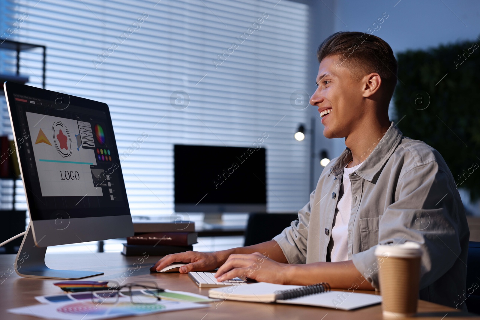 Photo of Designer working on computer indoors at night