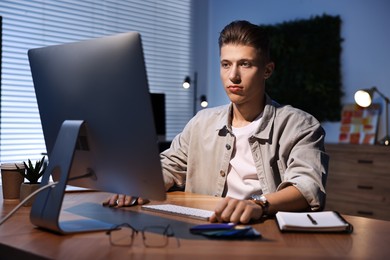 Photo of Designer working on computer indoors at night