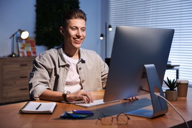 Photo of Designer working on computer indoors at night