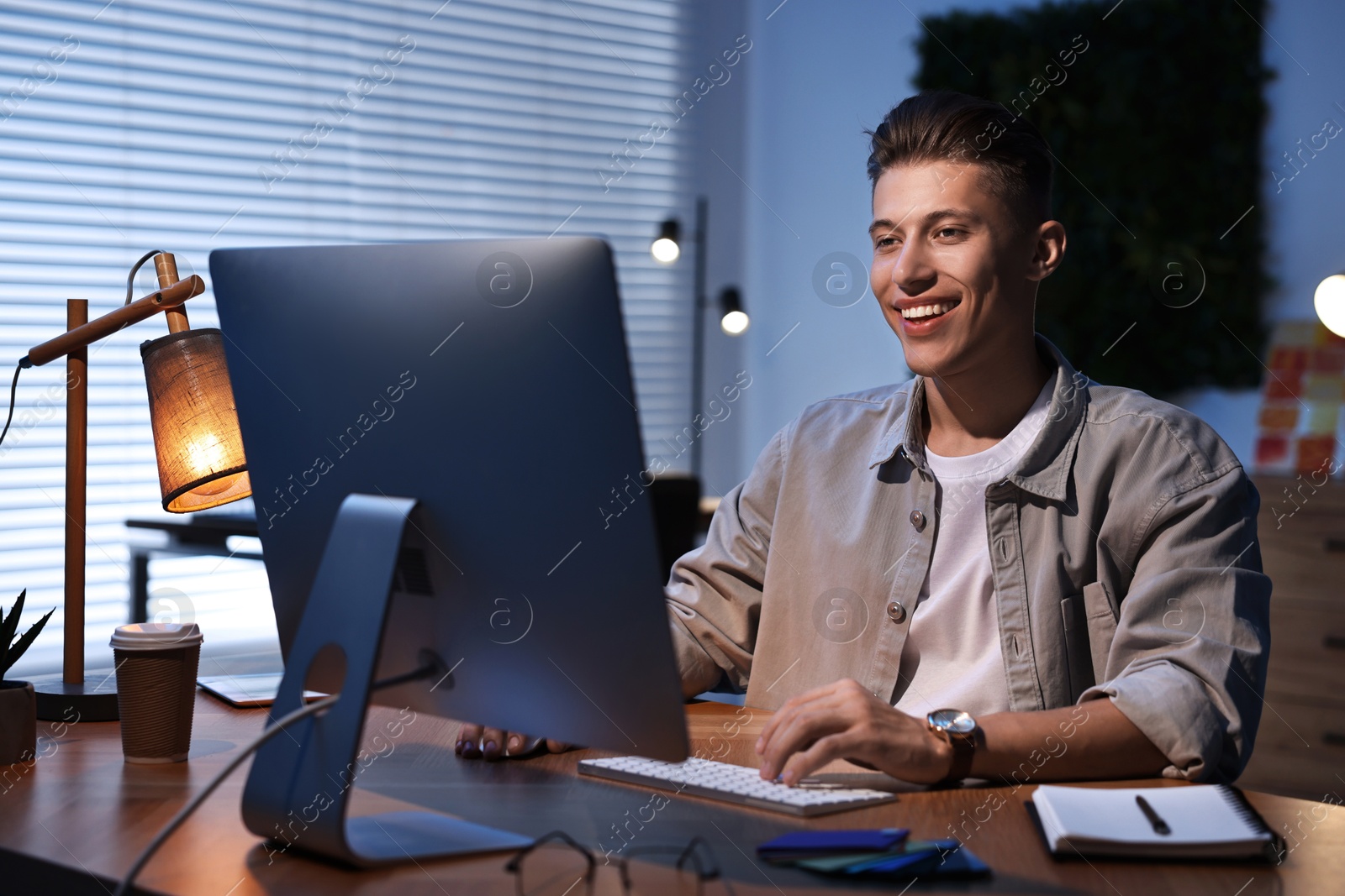 Photo of Designer working on computer indoors at night