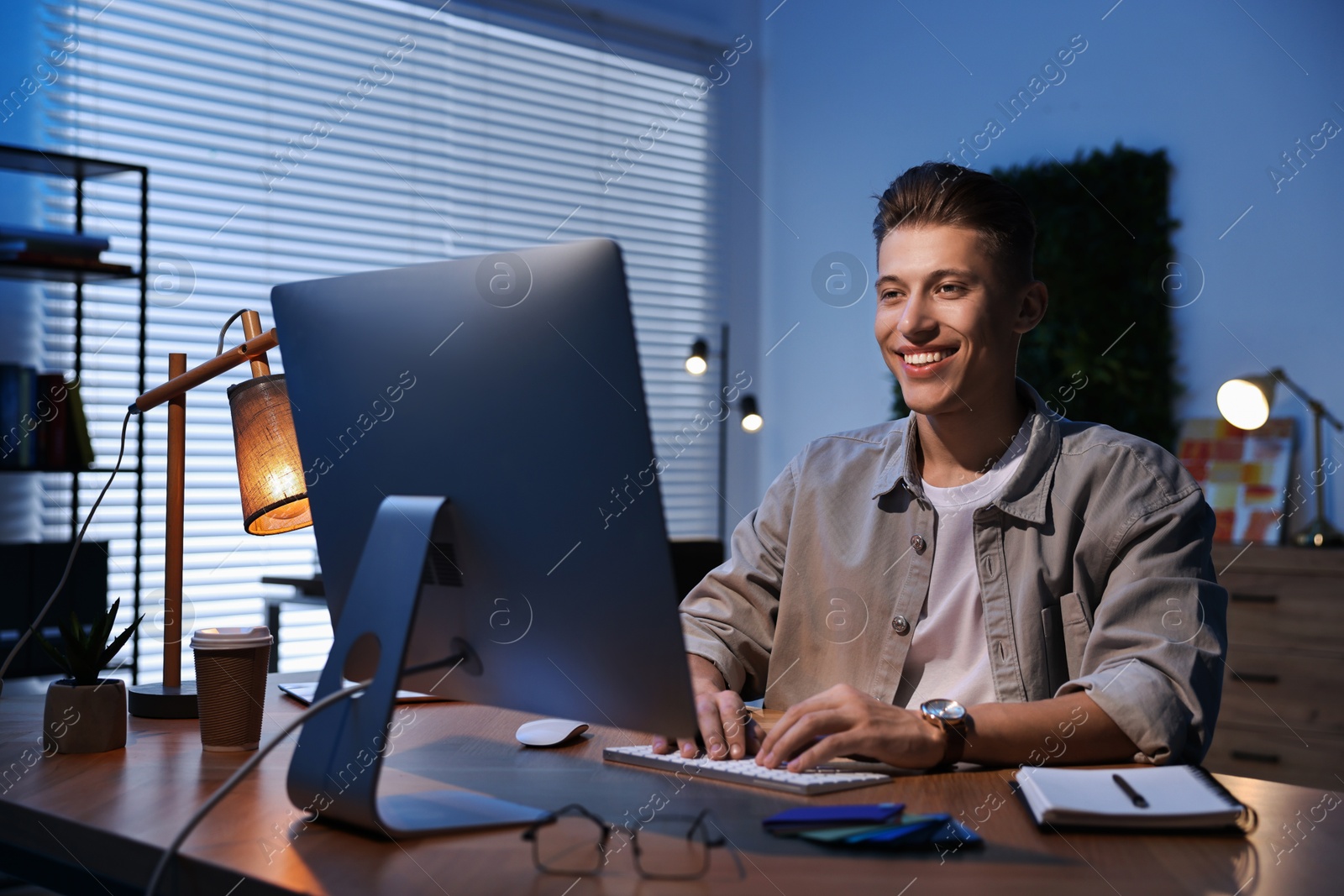 Photo of Designer working on computer indoors at night