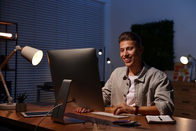 Designer working on computer indoors at night