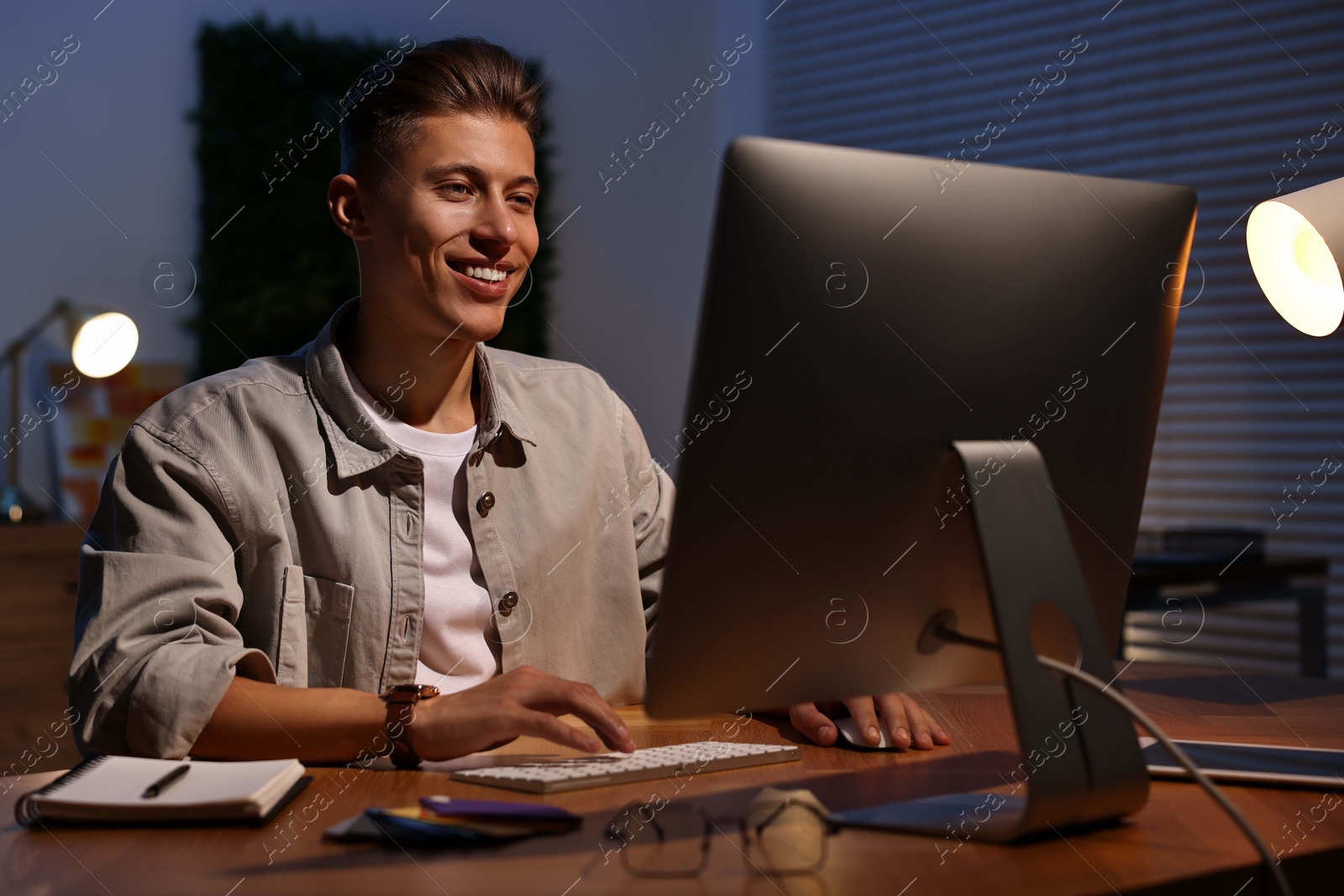 Photo of Designer working on computer indoors at night