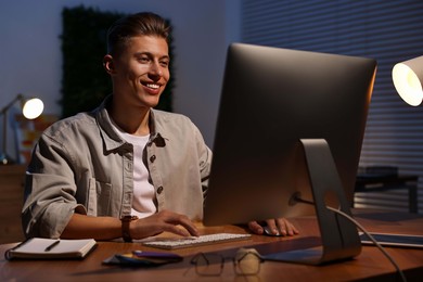 Designer working on computer indoors at night